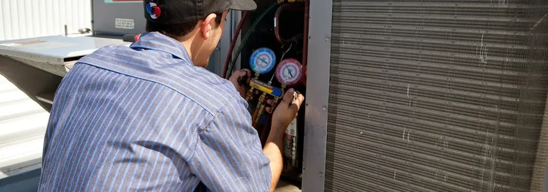HVAC technician servicing a condenser unit in Ontario