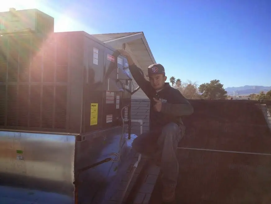 HVAC technician performing Air Duct Repair on a rooftop unit in Ontario